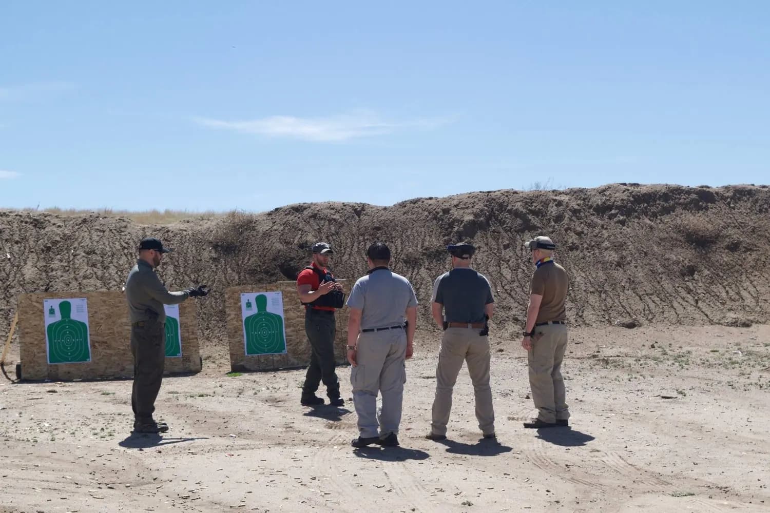 Officers training on a firearms range under instructor supervision